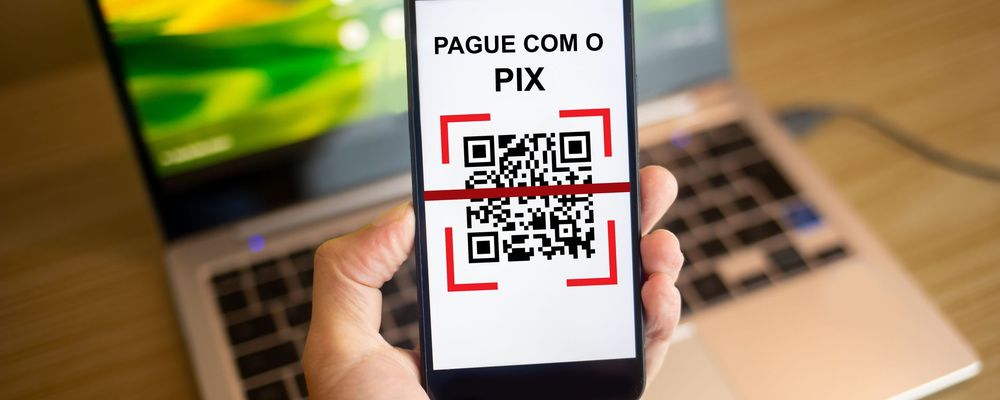 Montagem com ícone do Pix sobre notas de real