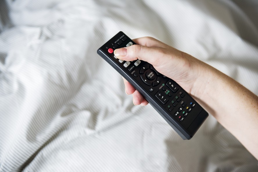 Controle remoto apontado para uma televisão ligada