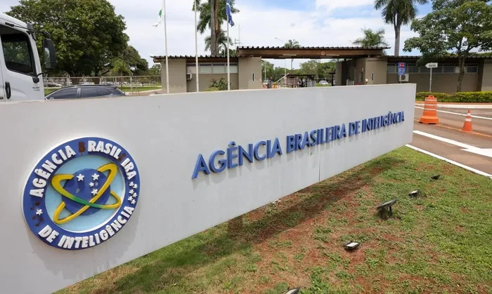 Imagem de agente público usando smartphone em ambiente institucional